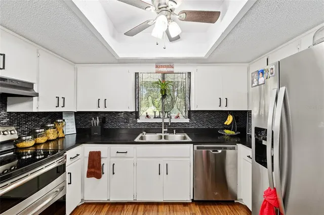 a kitchen with stainless steel appliances a stove a refrigerator a sink and cabinets