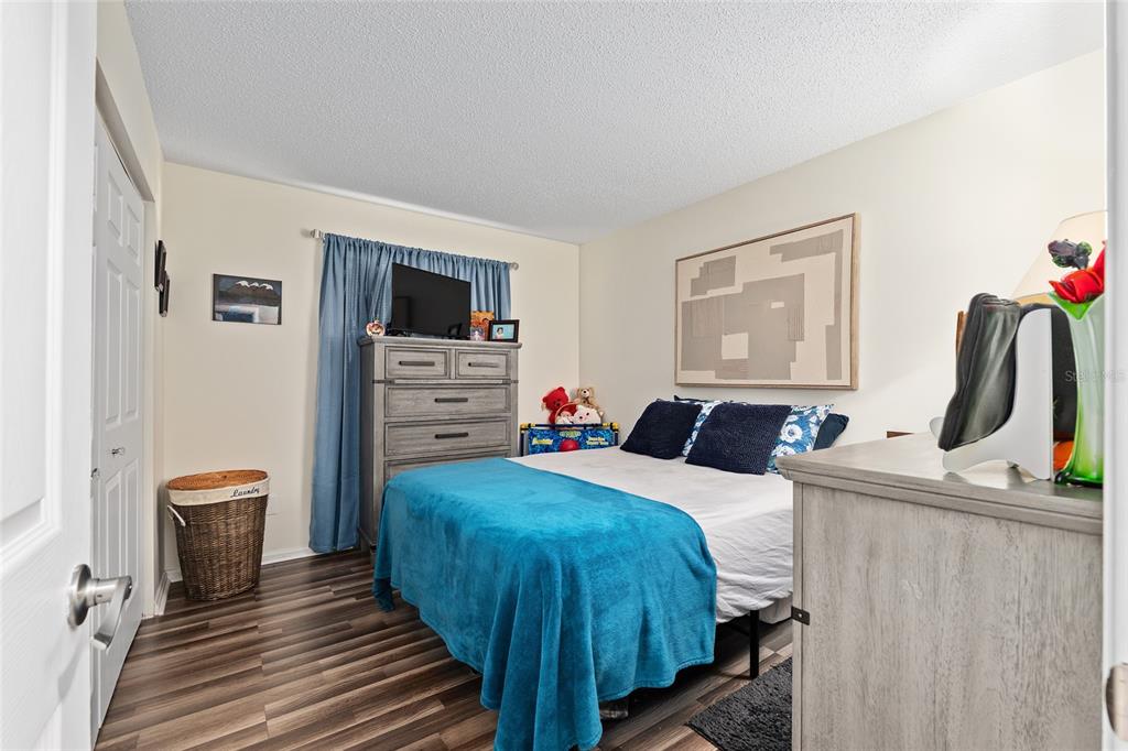 10182 Southwest 88th Court Ocala, FL 34481 - Photo 21 of 31 a bedroom with a bed and a flat screen tv