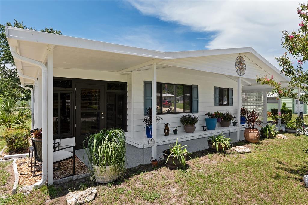 10182 Southwest 88th Court Ocala, FL 34481 - Photo 3 of 31 a view of a patio with table and chairs potted plants and floor to ceiling window