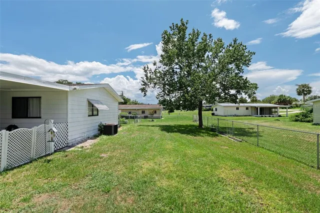 a view of a house with a big yard and potted plants