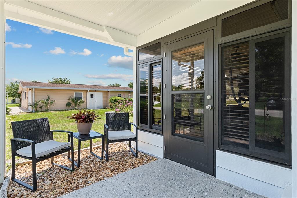 10182 Southwest 88th Court Ocala, FL 34481 - Photo 5 of 31 a view of a living room and kitchen with furniture and floor to ceiling window