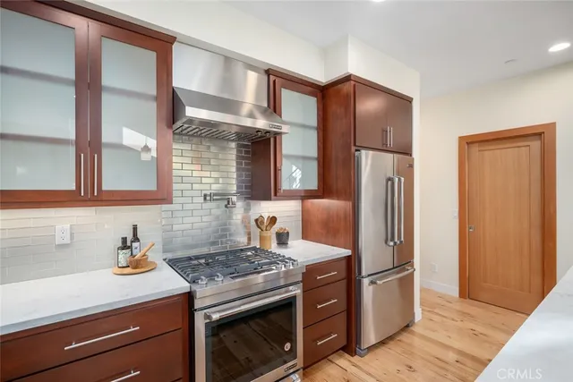 a kitchen with stainless steel appliances granite countertop a refrigerator and a stove