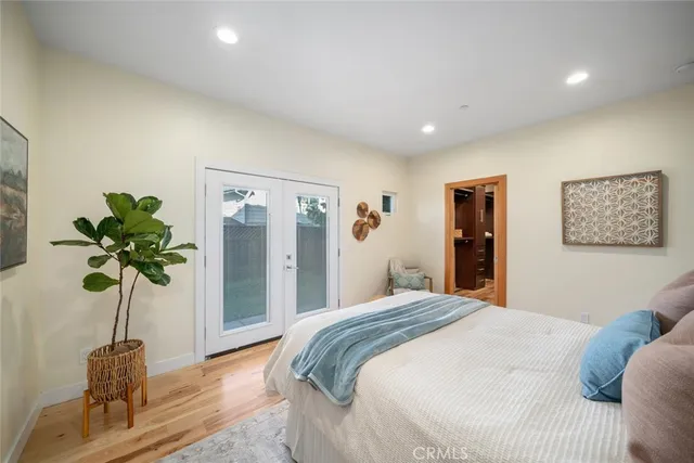 a bedroom with a large bed and a potted plant