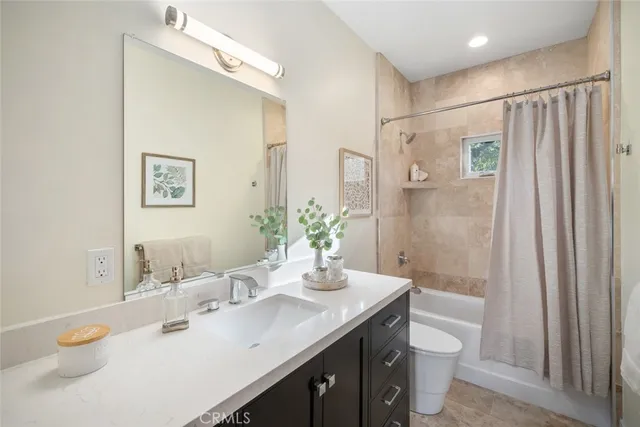 a bathroom with a granite countertop sink a toilet and shower