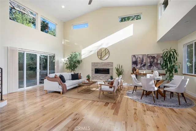 a living room with fireplace furniture and a large window