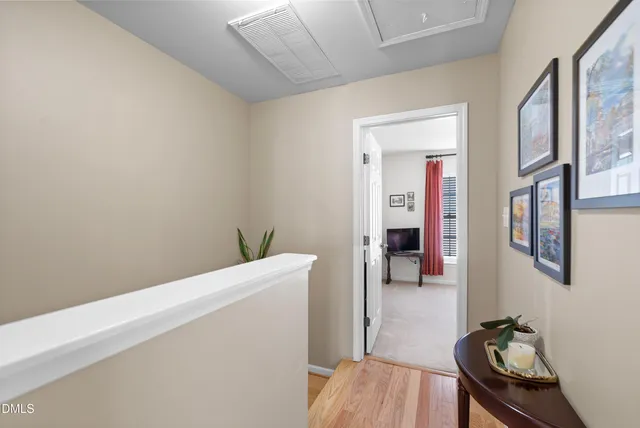 a walk in closet with wooden floor