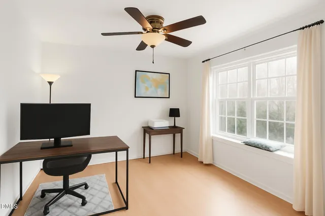 a view of a livingroom with workspace and a window