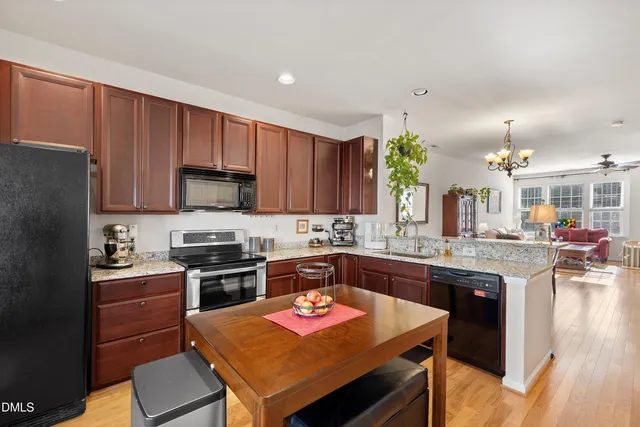 a dining room with wooden floor a chandelier a wooden table and chairs
