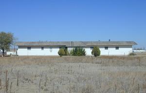 a front view of a house with a yard and a lake view