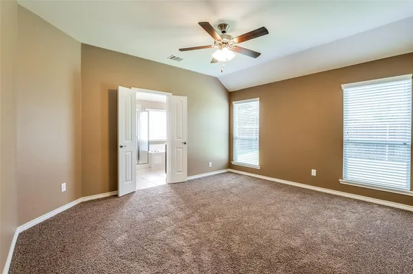 an empty room with a ceiling fan and a window
