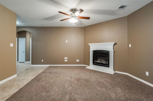 a view of a livingroom with a fireplace and a chandelier fan