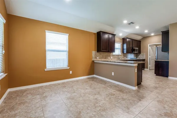 a kitchen with stainless steel appliances granite countertop a stove refrigerator sink and a microwave