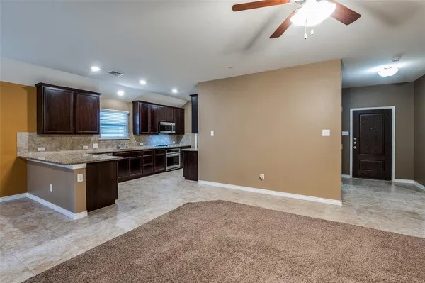 a large kitchen with a large counter top stainless steel appliances and cabinets