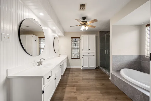 a bathroom with a tub shower and sink