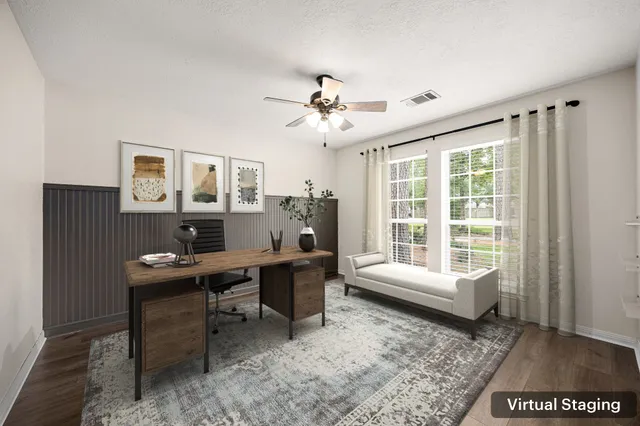 an empty room with wooden floor and fan