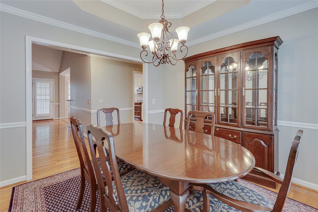 302 Wild Rice Drive Simpsonville, SC 29681 - Photo 20 of 44 Polished hardwood flooring and elegant chair rail molding frame the formal dining room.