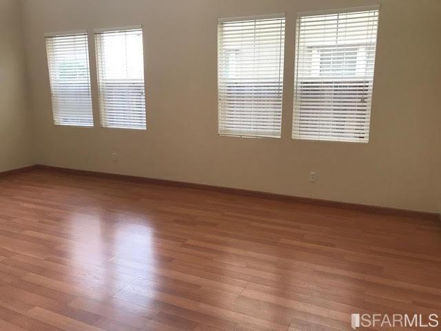 1228 Alder Creek Circle San Leandro, CA 94577 - Photo 2 of 9 a view of an empty room with wooden floor and a window