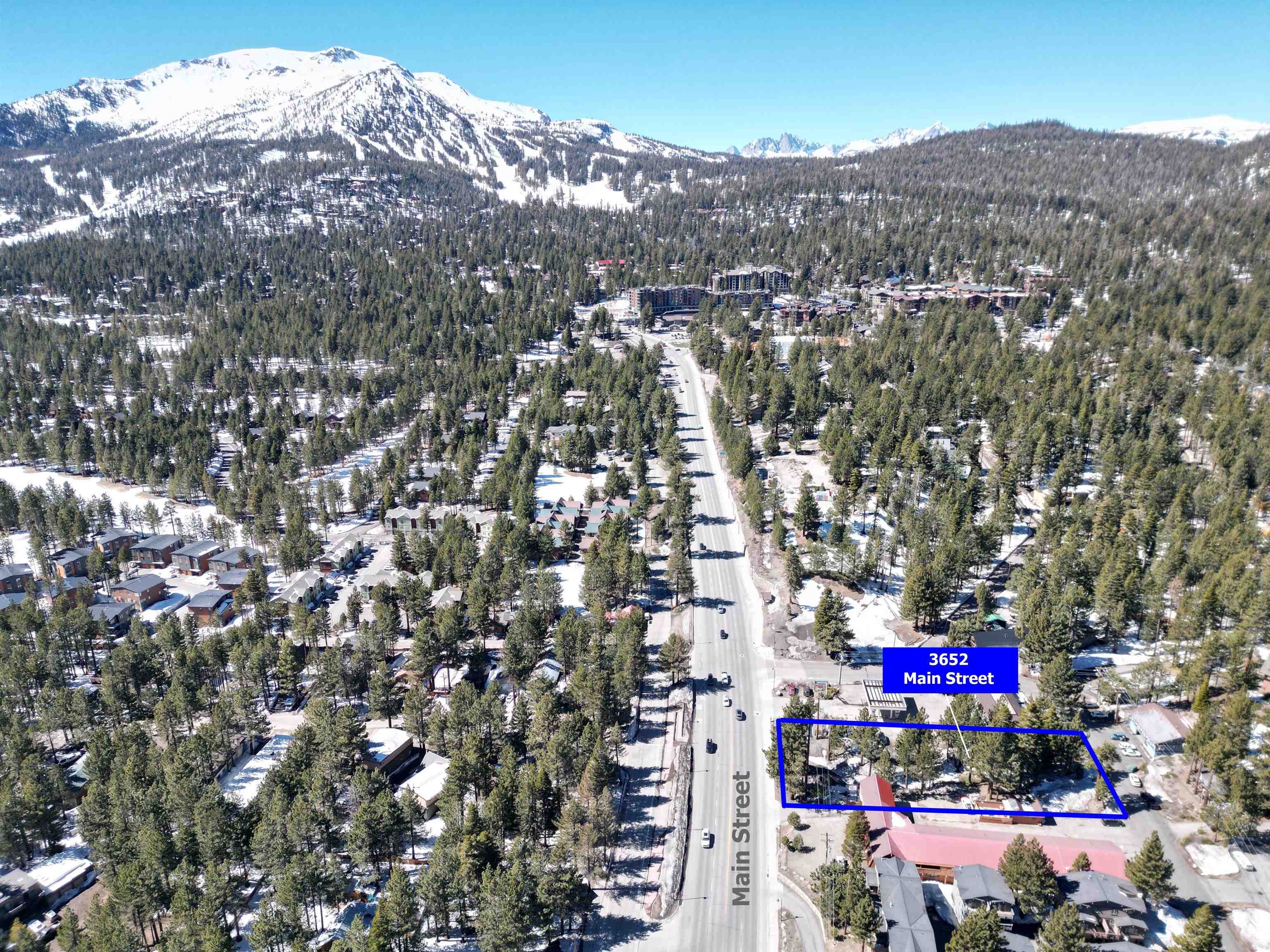 Aerial view of property and surrounding area featuring mountains and property boundaries highlighted