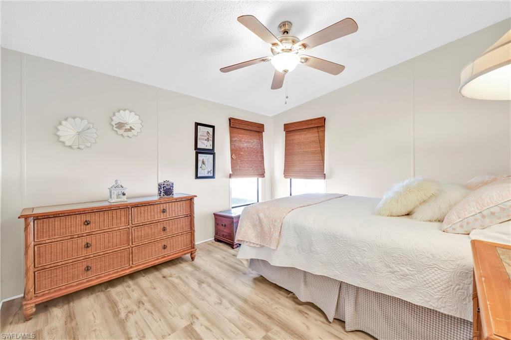 41 Oceans Boulevard, Unit 41 Naples, FL 34104 - Photo 11 of 32 a bedroom with a large bed and a chandelier