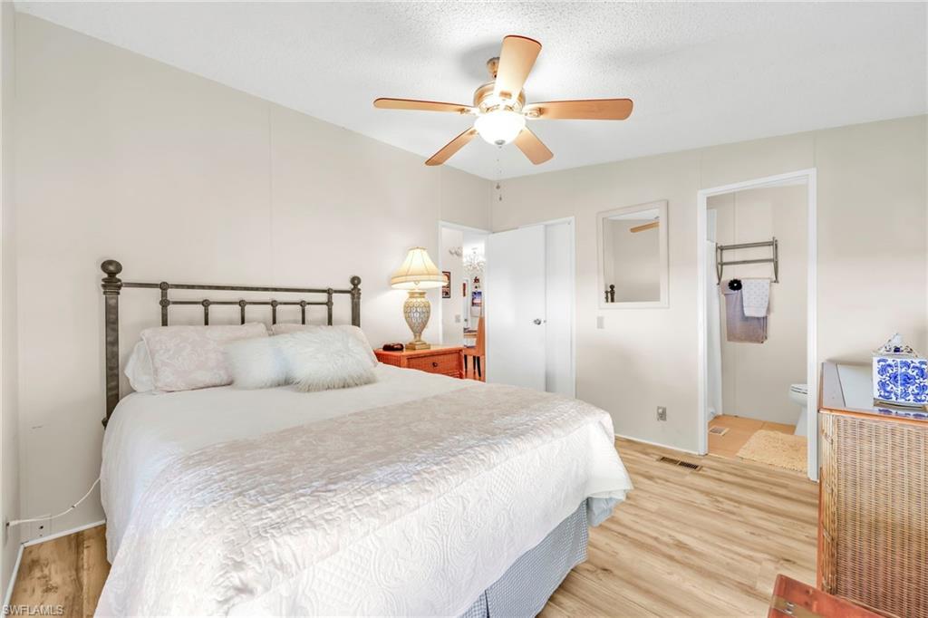 41 Oceans Boulevard, Unit 41 Naples, FL 34104 - Photo 13 of 32 a bedroom with a bed and a chandelier