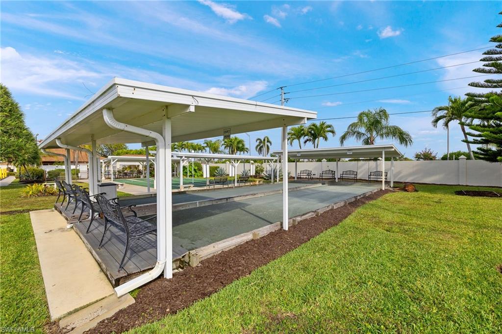 41 Oceans Boulevard, Unit 41 Naples, FL 34104 - Photo 28 of 32 a view of a patio with table and chairs under an umbrella