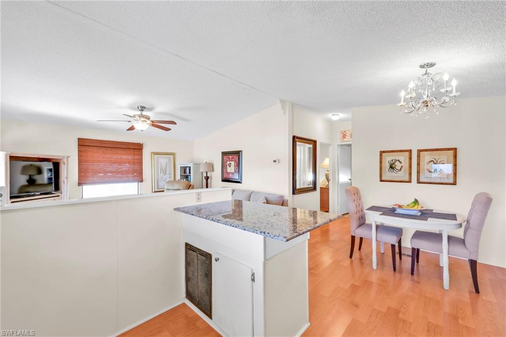 41 Oceans Boulevard, Unit 41 Naples, FL 34104 - Photo 32 of 32 a living room with furniture and a chandelier