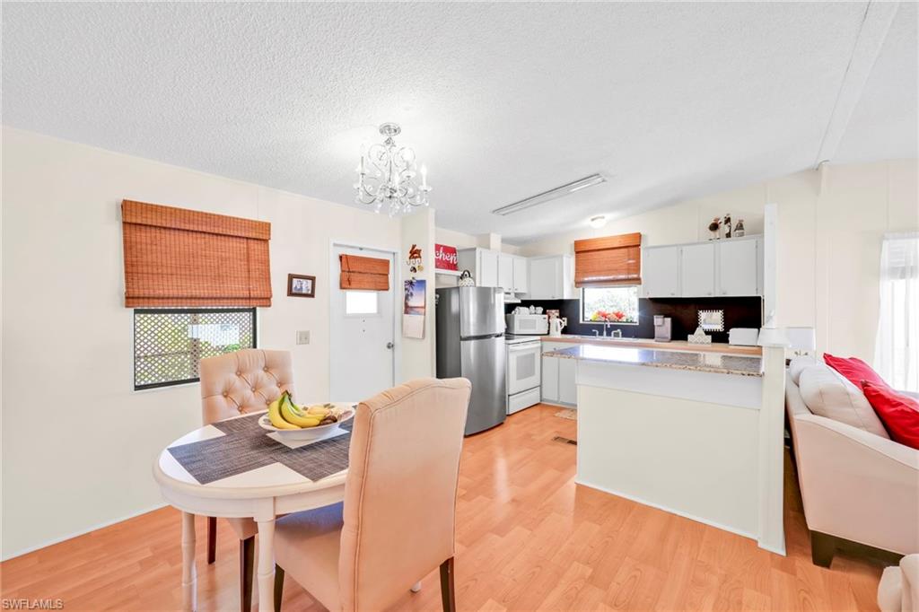 41 Oceans Boulevard, Unit 41 Naples, FL 34104 - Photo 6 of 32 a living room with kitchen island furniture and a chandelier