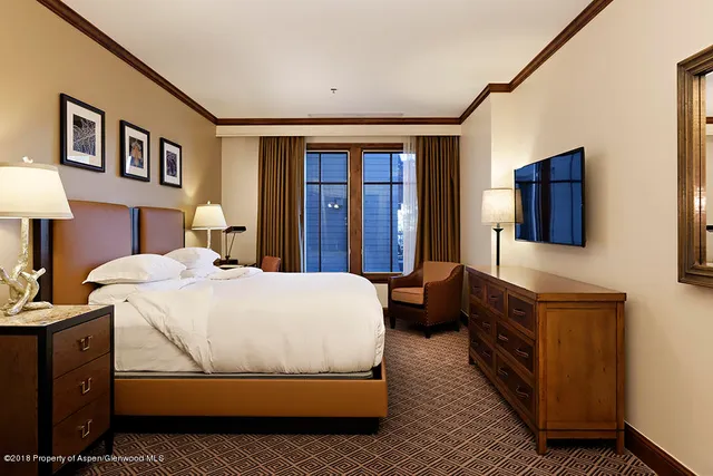 a bedroom with a bed and dresser with mirror