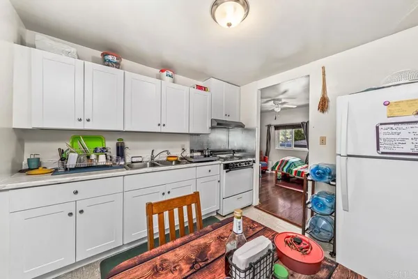 a kitchen with granite countertop lots of clutter and stainless steel appliances