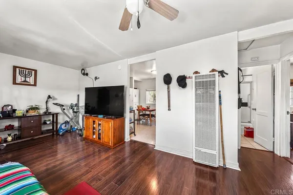 a view of a livingroom with wooden floor and a flat screen tv