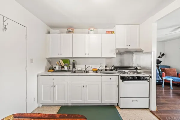 a kitchen with cabinets appliances and wooden floor
