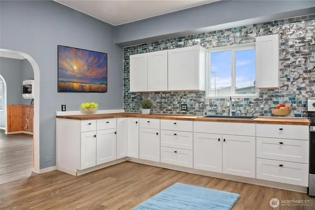 a view of cabinets a wooden floor and a window in a room