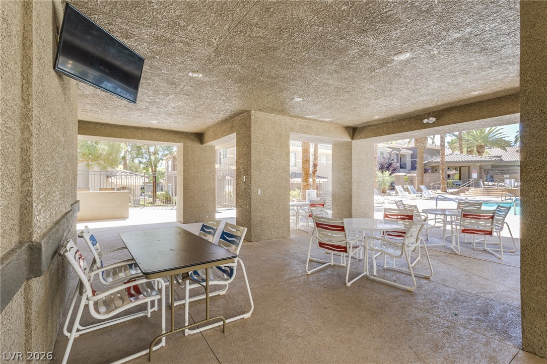 9050 West Warm Springs Road, Unit 1011 Las Vegas, NV 89148 - Photo 26 of 32 Enjoy outdoor dining and relaxation in this shaded patio area beside the community pool.