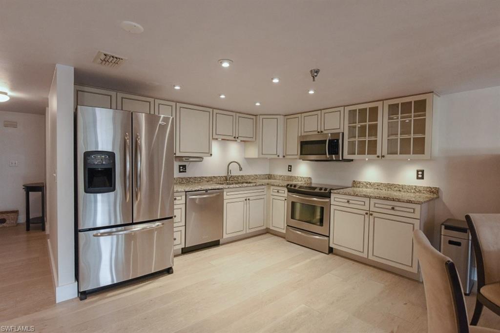 a kitchen with granite countertop stainless steel appliances and refrigerator