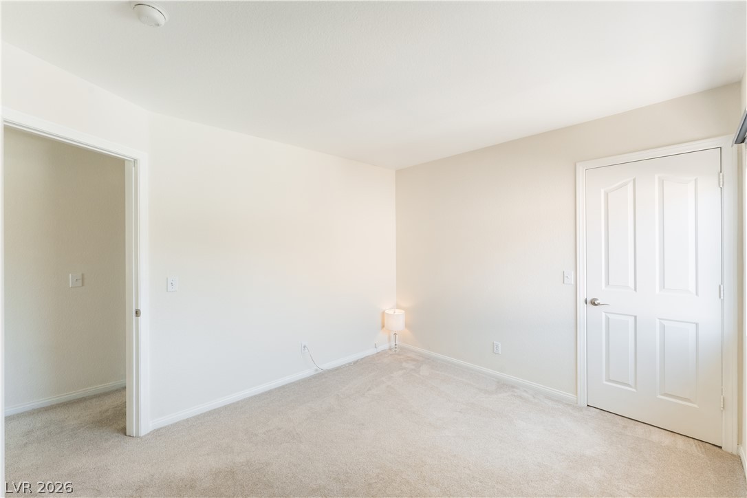 8872 Chapman Point Las Vegas, NV 89129 - Photo 19 of 29 A quiet room featuring soft carpeting and a classic paneled door.