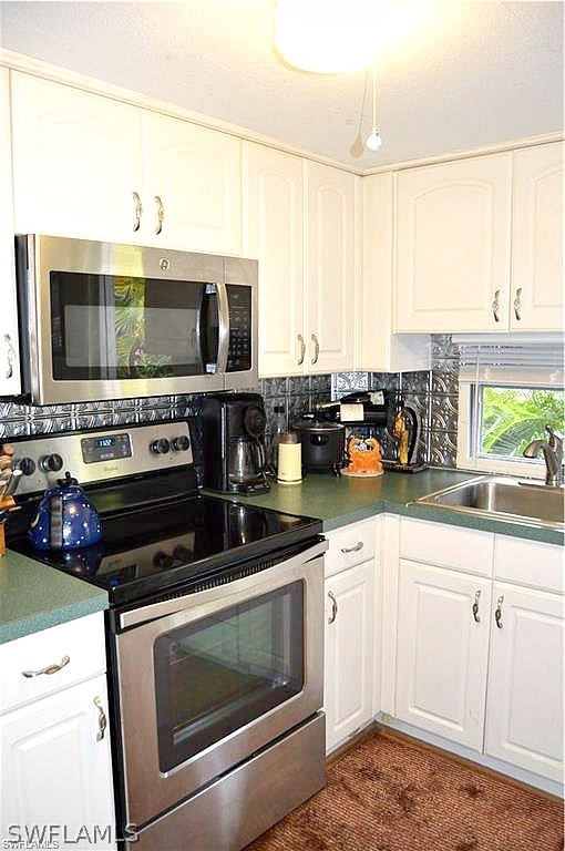2591 Cay Cove Matlacha, FL 33993 - Photo 12 of 20 a kitchen with stainless steel appliances a stove a sink and a microwave