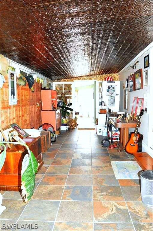 2591 Cay Cove Matlacha, FL 33993 - Photo 19 of 20 a view of a patio with table and chairs potted plants with wooden floor