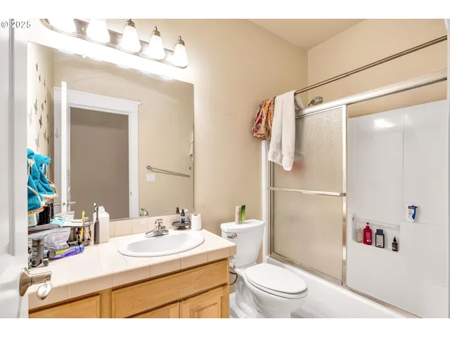 a bathroom with a sink toilet vanity and shower