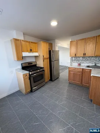 a kitchen with stainless steel appliances a stove a sink a microwave and a refrigerator