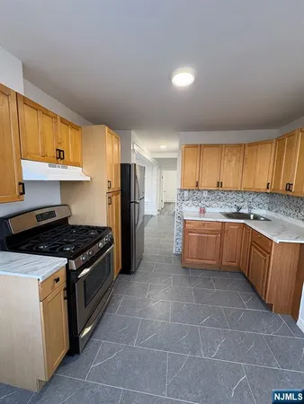 a kitchen with stainless steel appliances granite countertop a stove a sink dishwasher and a refrigerator