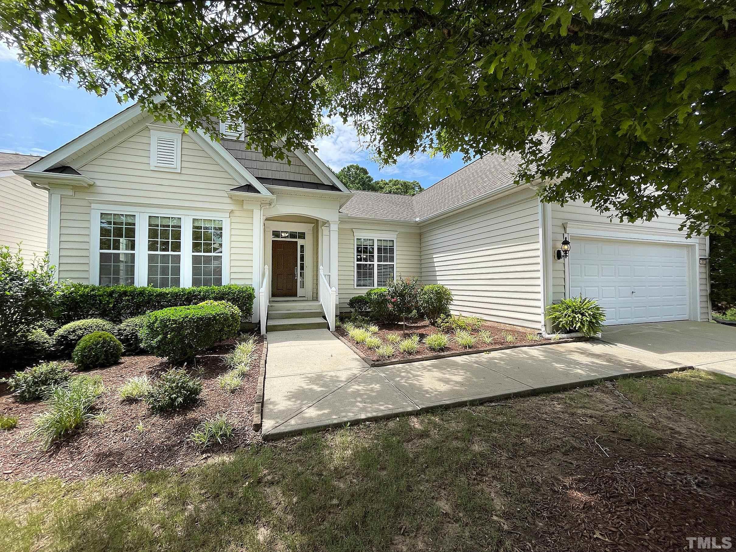 a view of a house with a yard and large tree