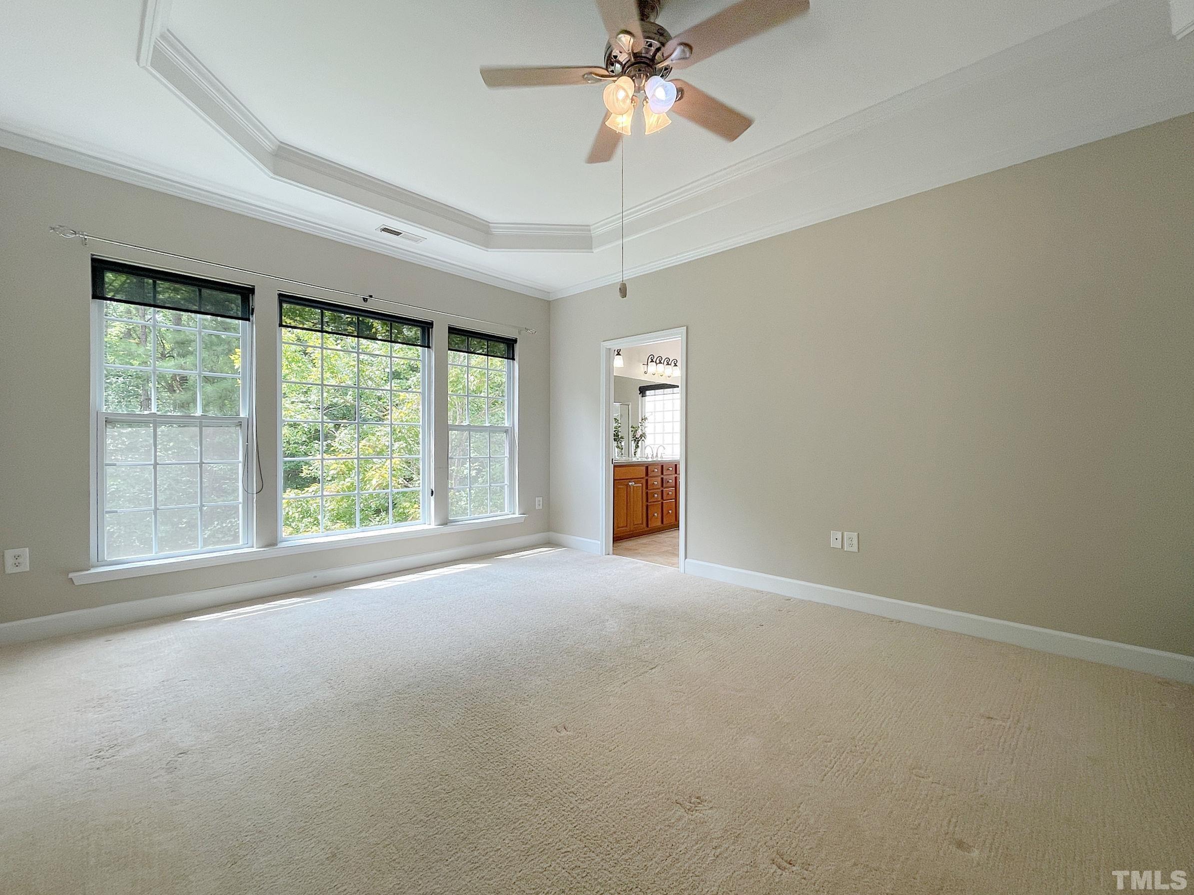207 Beckingham Loop Cary, NC 27519 - Photo 16 of 40 an empty room with windows and chandelier fan