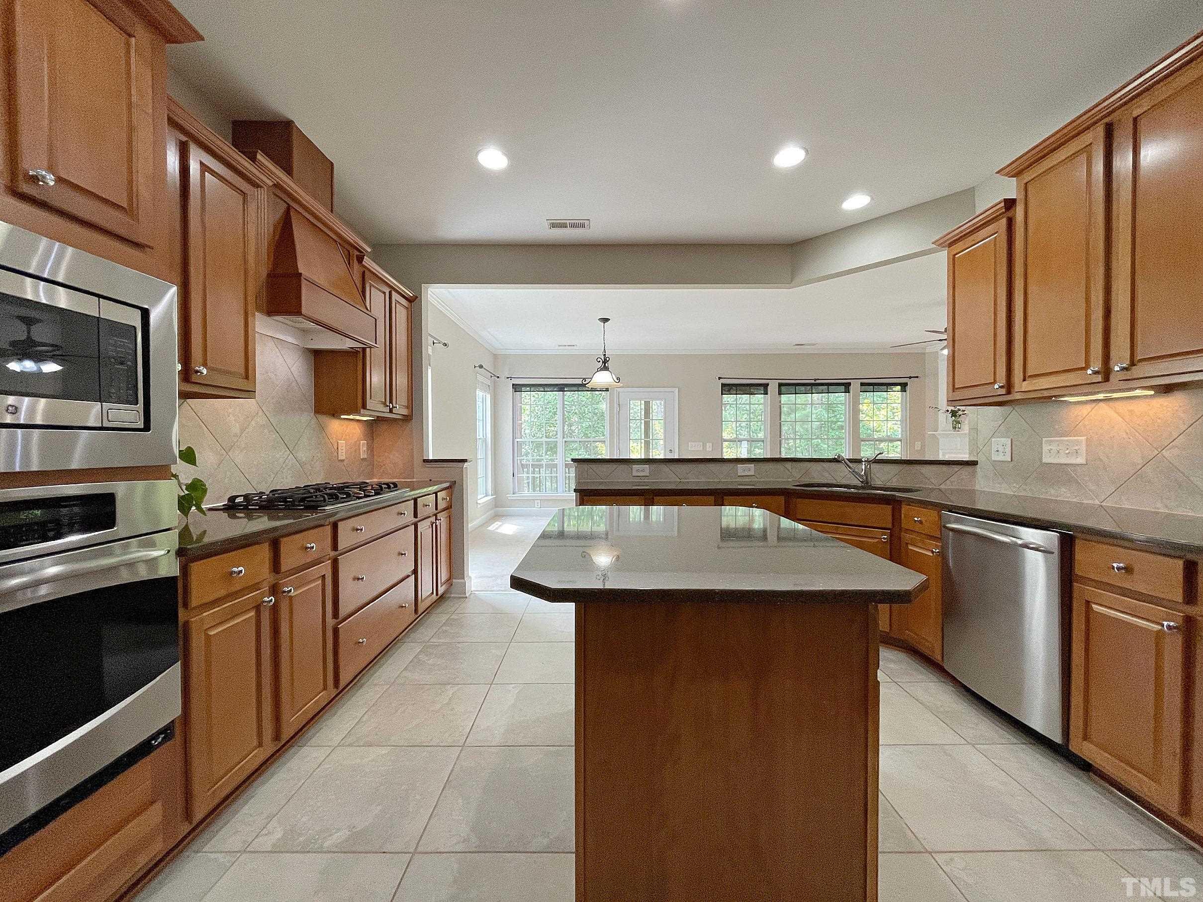 207 Beckingham Loop Cary, NC 27519 - Photo 7 of 40 a kitchen with stainless steel appliances granite countertop a sink stove and cabinets