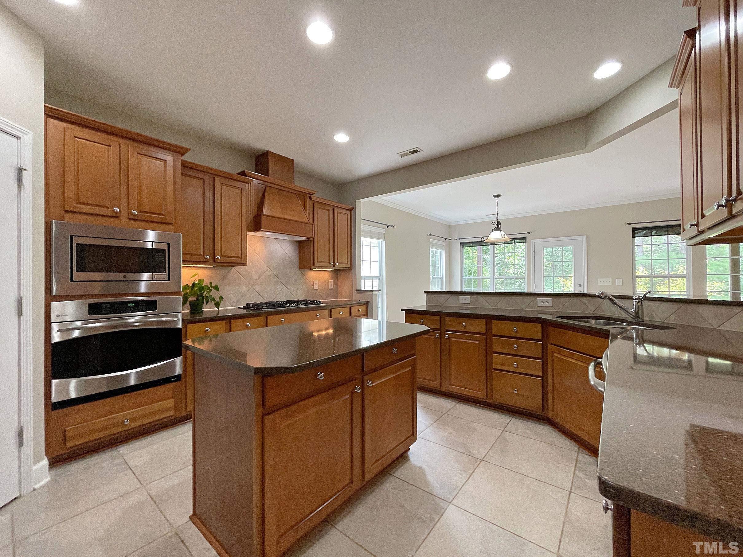 207 Beckingham Loop Cary, NC 27519 - Photo 8 of 40 a kitchen with stainless steel appliances granite countertop a sink counter space cabinets and a large window