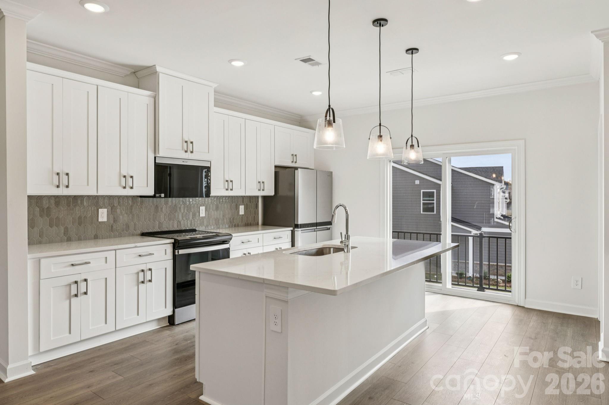347 Golden Maple Court Fort Mill, SC 29708 - Photo 7 of 21 a large kitchen with stainless steel appliances kitchen island granite countertop a sink a stove and a wooden floors