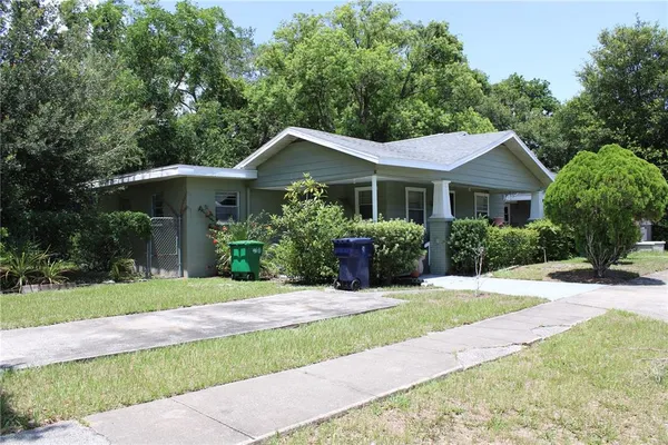 a front view of a house with a yard and potted plants