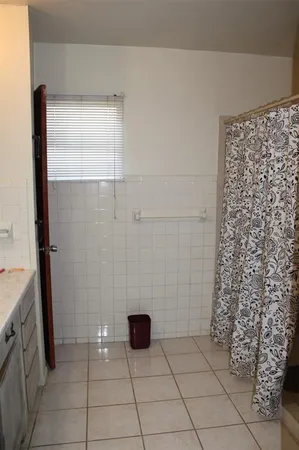 a bathroom with a granite countertop shower and a mirror