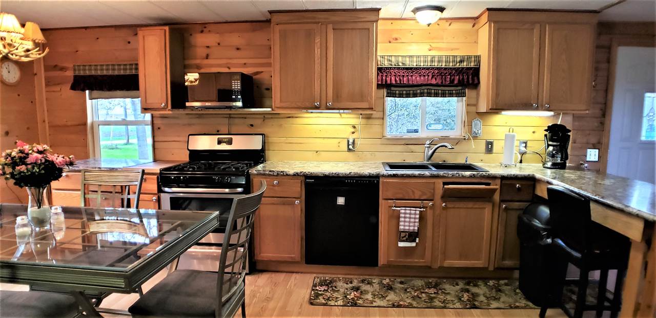 1573 Burkett Road Dixon, IL 61021 - Photo 6 of 25 a kitchen with granite countertop a stove a sink and a wooden cabinets