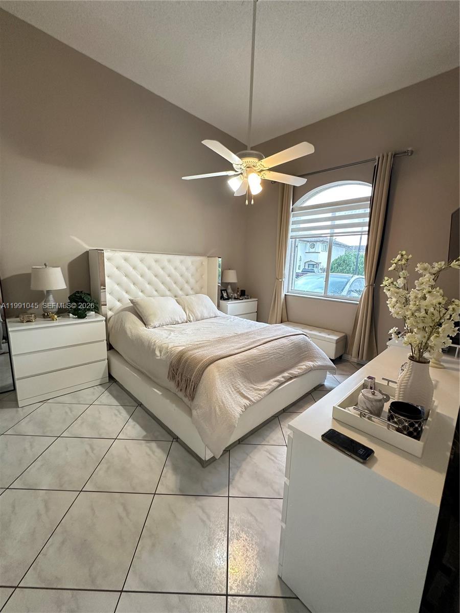 15318 Southwest 41st Terrace Miami, FL 33185 - Photo 13 of 30 a bedroom with a bed and a chandelier