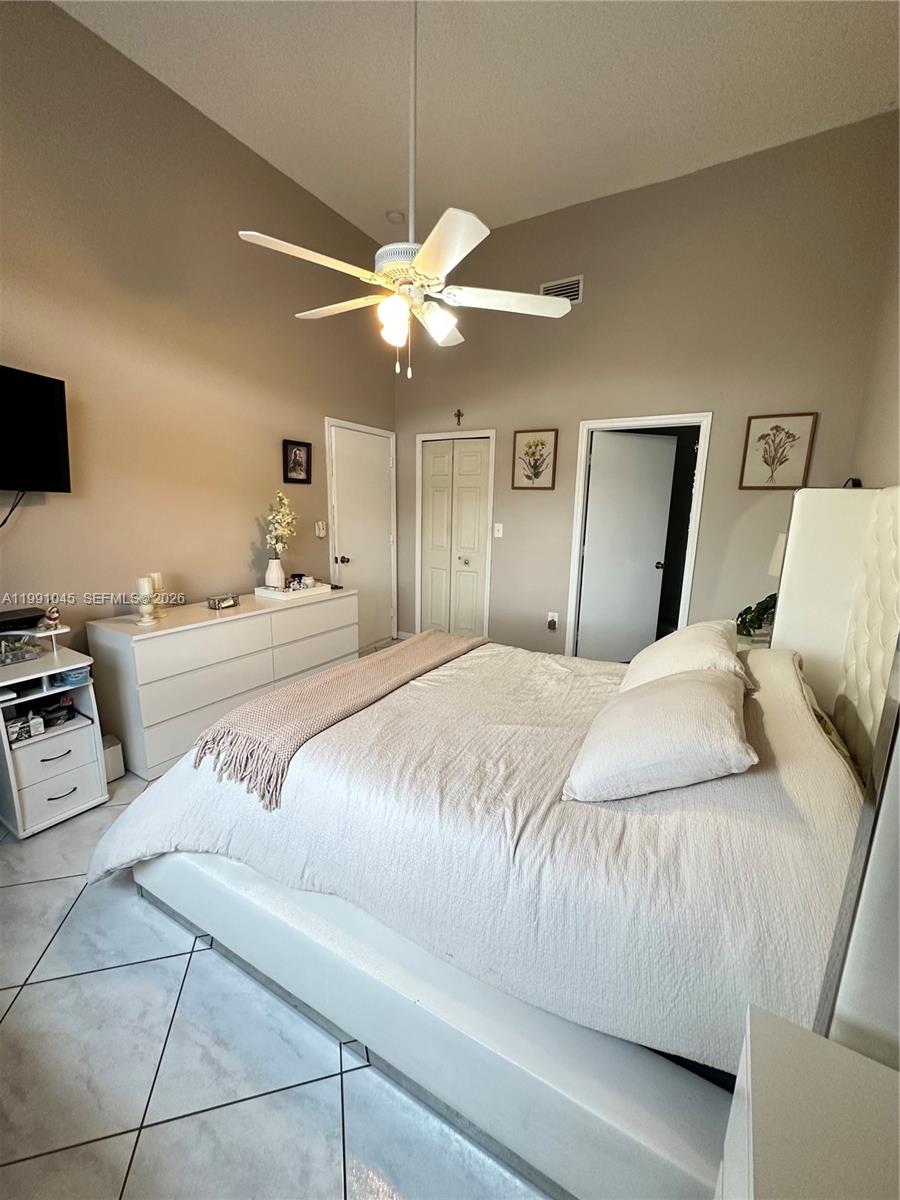 15318 Southwest 41st Terrace Miami, FL 33185 - Photo 14 of 30 a bedroom with a large bed and a ceiling fan
